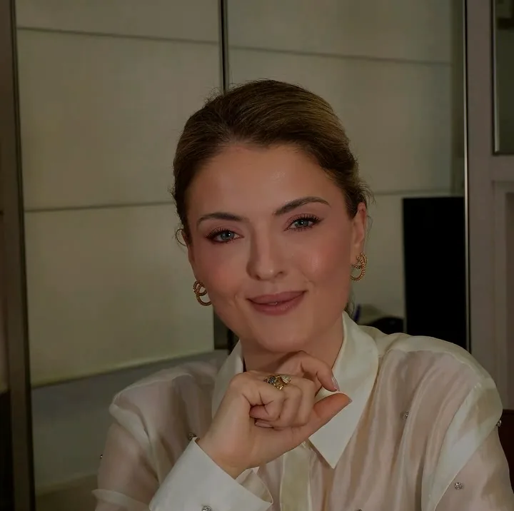 Danusa Gazolla sentada à mesa do consultório, sorrindo